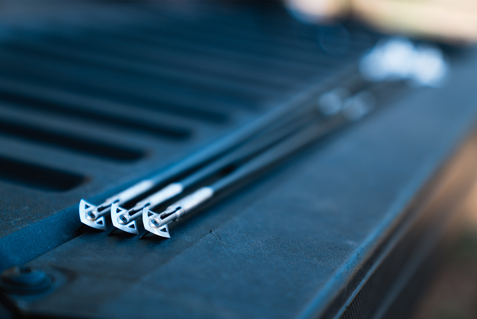 3 broadheads from a crossbow laid out on a truck bed