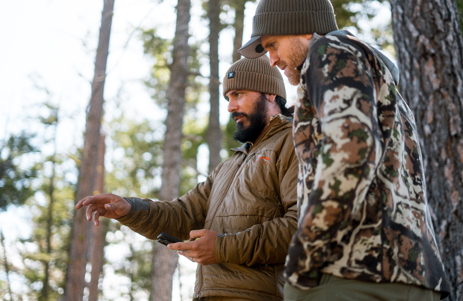 two hunters in a tree lined forest 