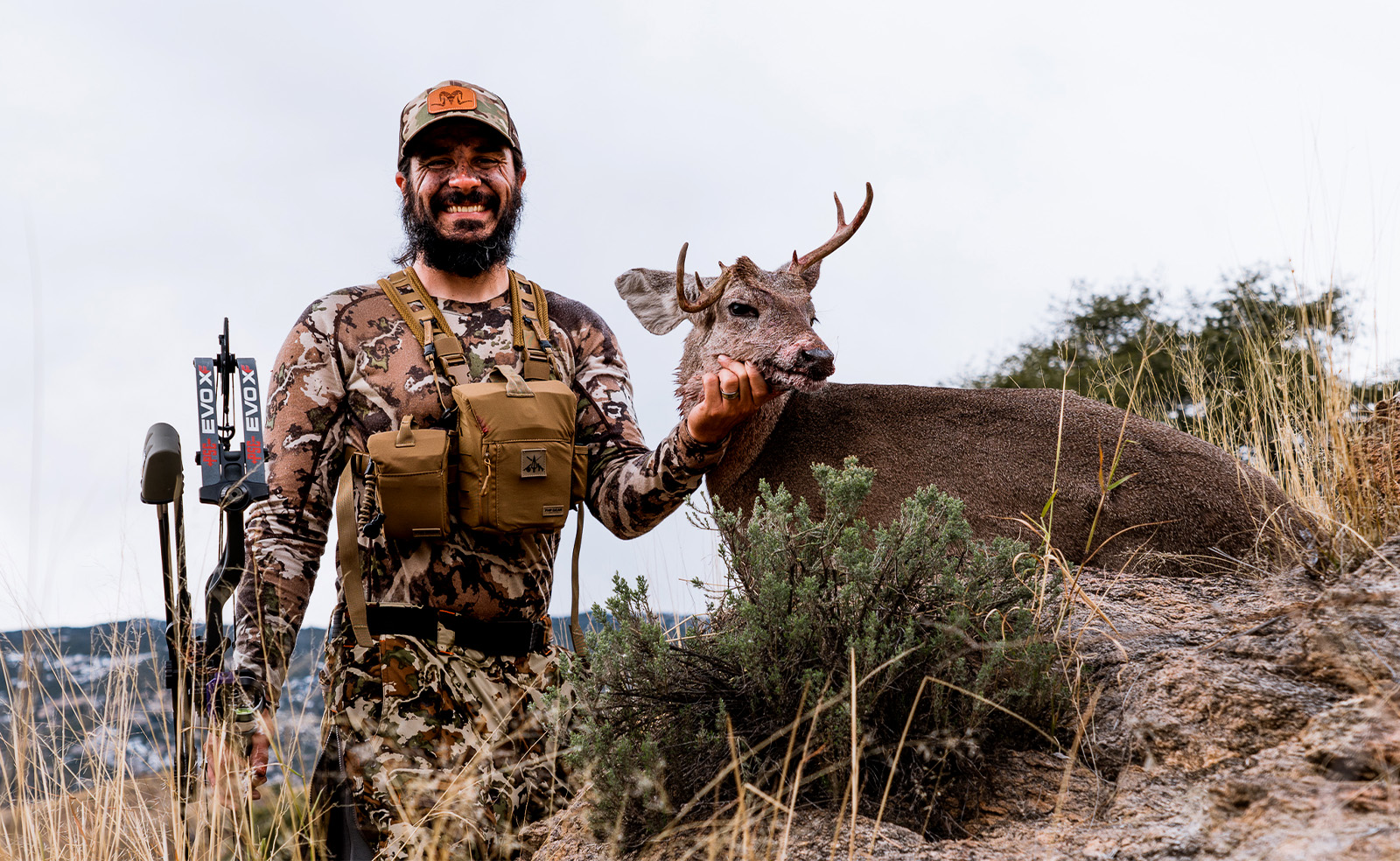 Arizona hunter in camo with a deer he brought down with a hunting bow 