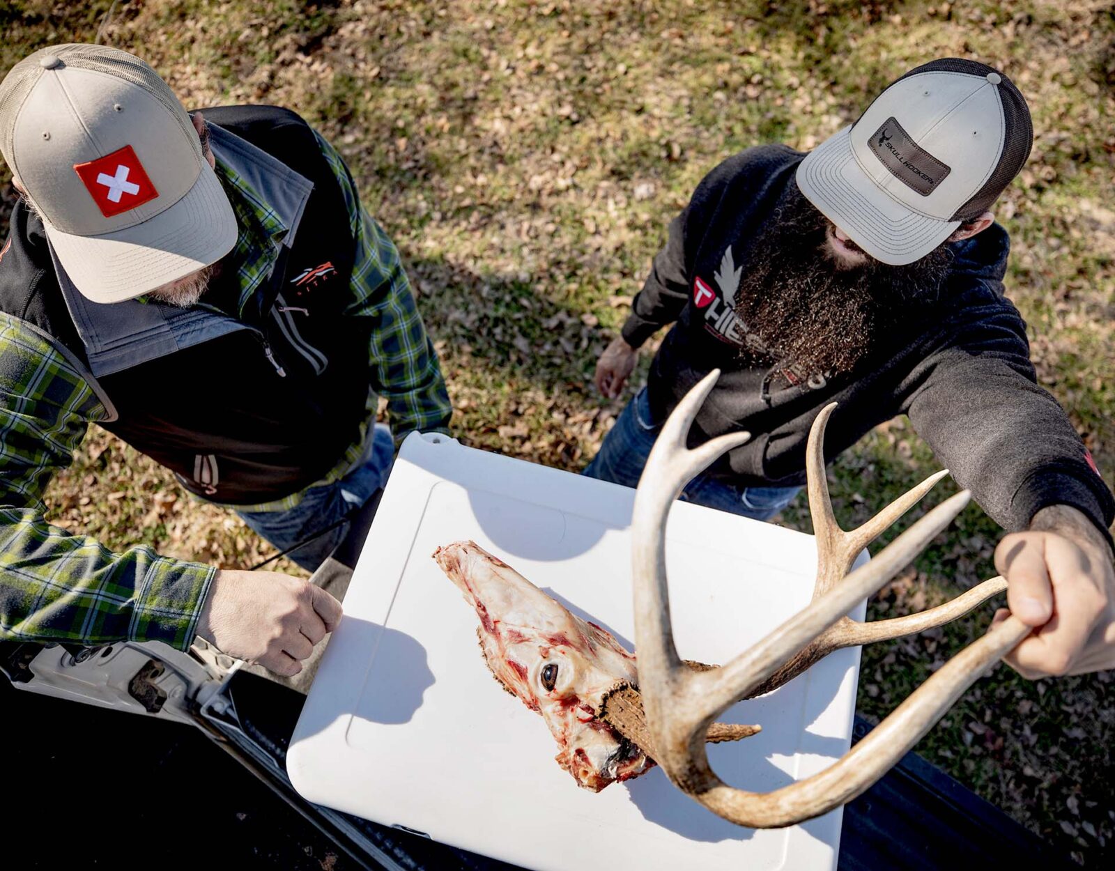 Two hunters DIY score deer antlers back at the truck. 