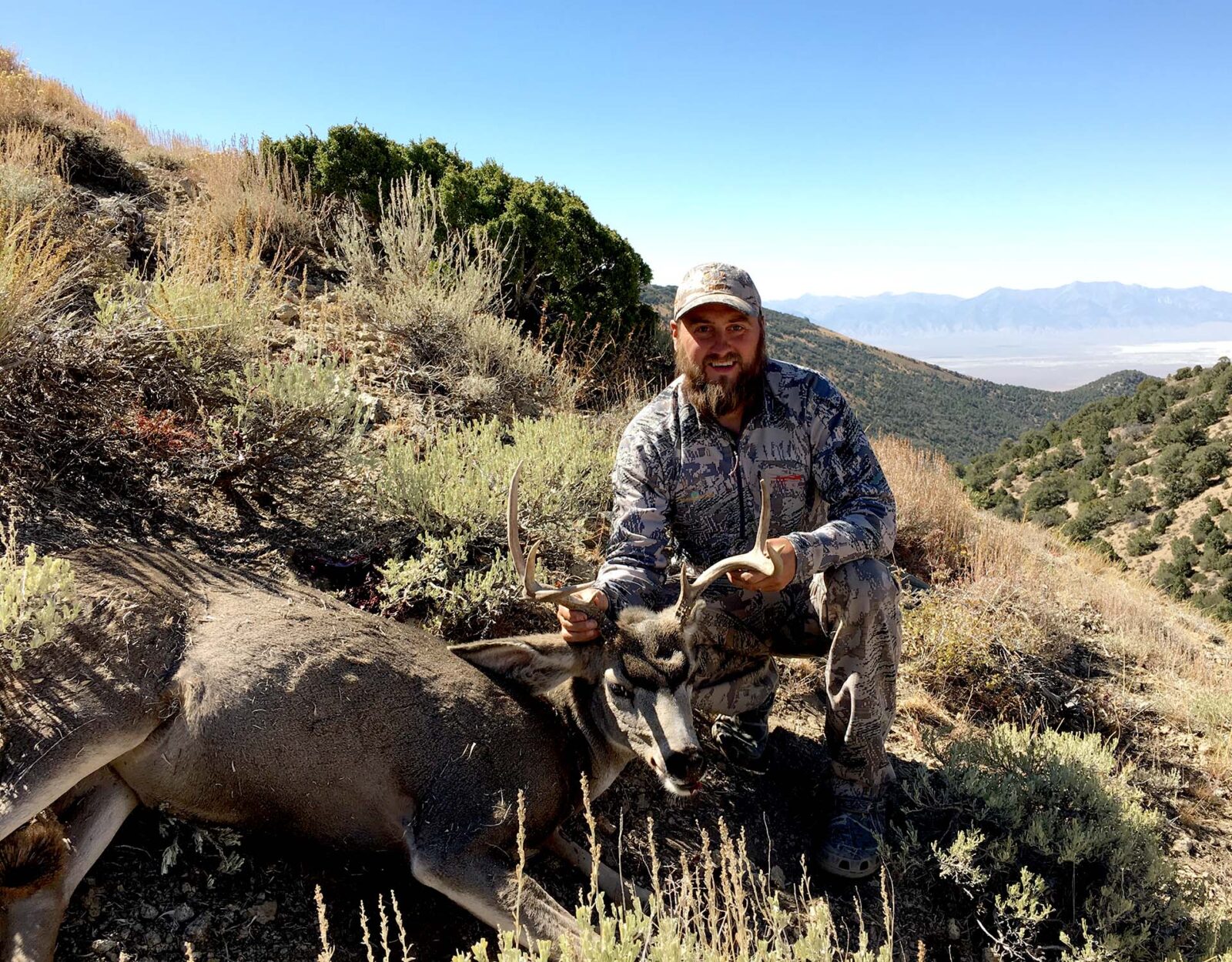 A hunter poses with the deer he harvested with a muzzleloader.