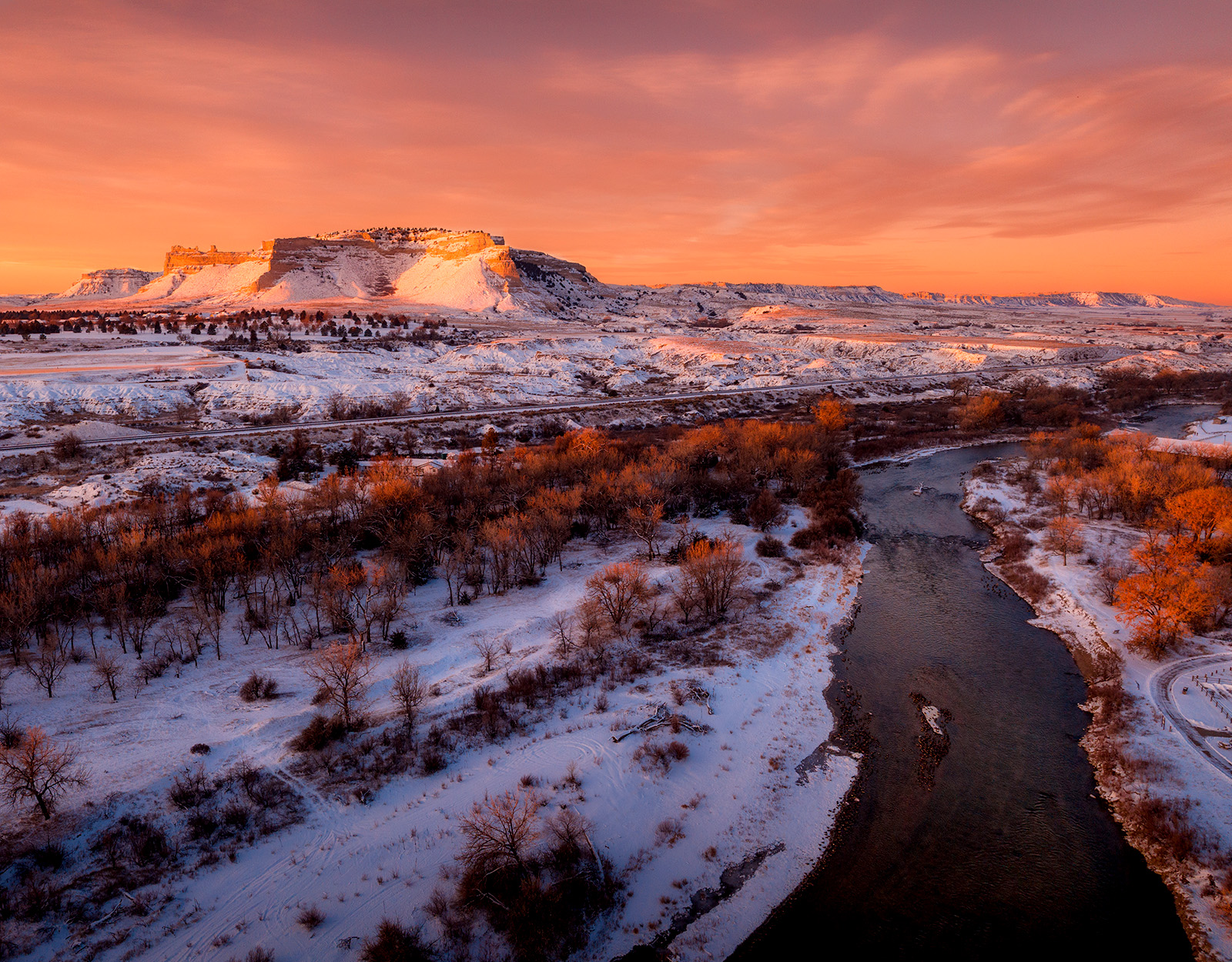 A waterway through snowy hill country.