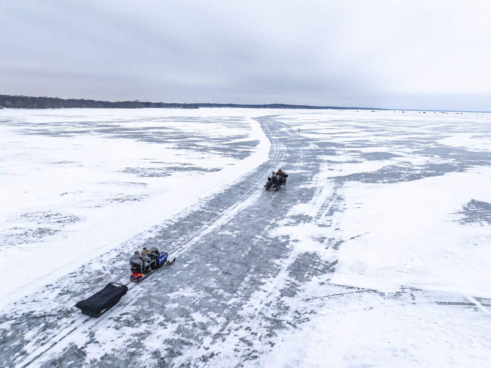 Snowmobilers on a frozen lake