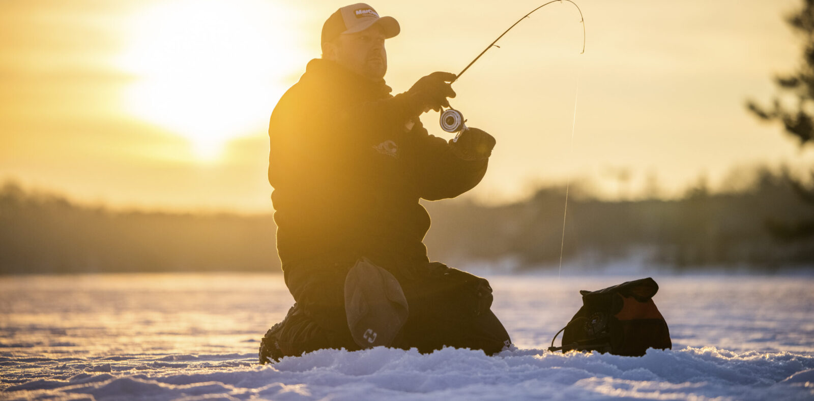 Man ice fishing on a frozen lake