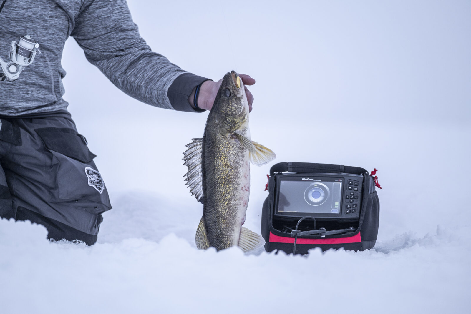 pulling a fish out of an iced over lake 