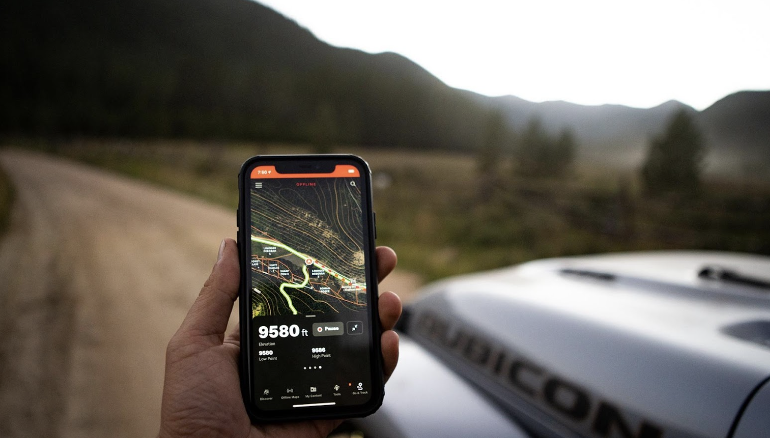 onX Offroad app being used on a trail with a Rubicon in the background